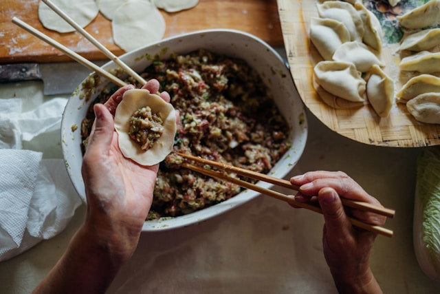 Hands making traditional Chinese dumplings
